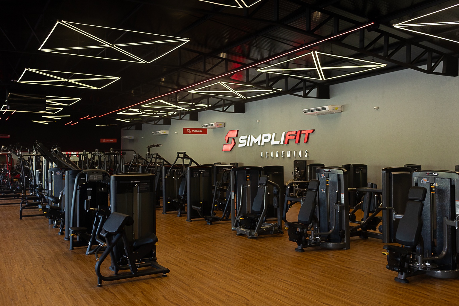 Unidade da Simplifit Academias com salão amplo, aparelhos modernos e iluminação planejada